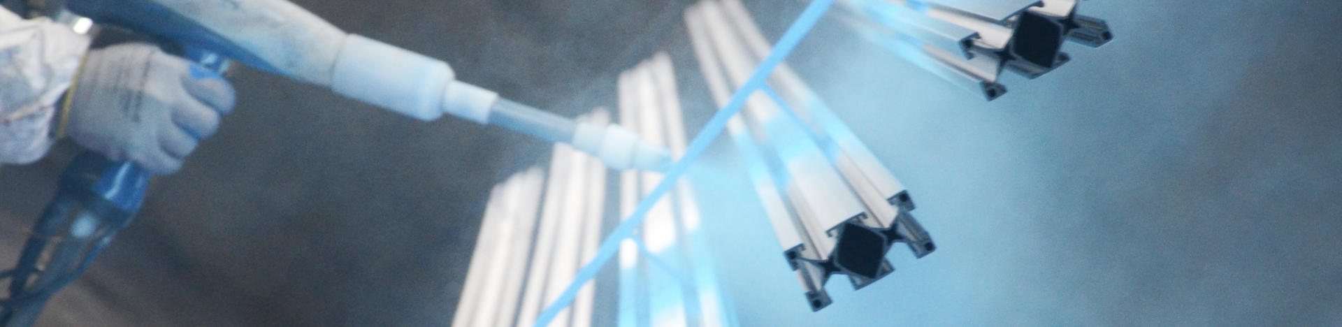 A close up of a Keystone Koating employee spraying blue powder on product