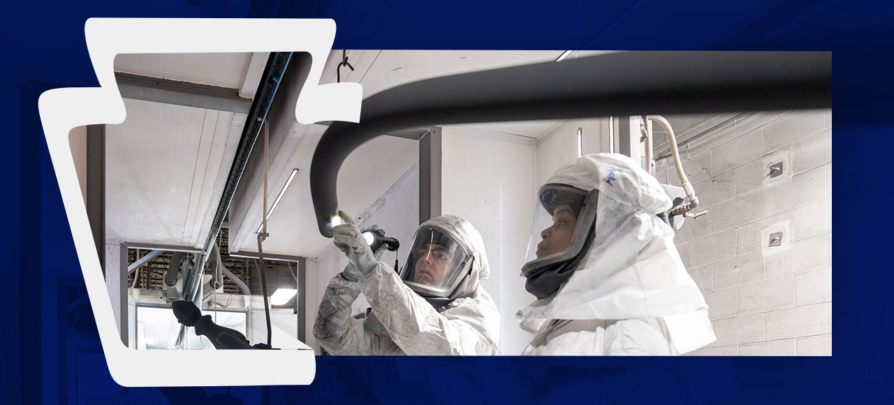 Keystone Koating banner with employees spraying powder coating on product